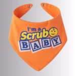 Image Description: A promotional product hero image of an orange bandana-style baby bib set against a neutral gradient background, featuring the blue and yellow text "I'm a Scrub Baby" alongside a smiley-face icon.