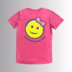 Image Description: A promotional product image showing the back of the vibrant pink short-sleeve t-shirt set against a neutral gradient background, featuring a large yellow smiley-face graphic wearing a pink bow, outlined in dark blue, above the purple URL text "scrubmommy.com".