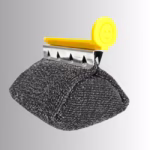 Image Description: A promotional product hero image of a single black bristle-free scrubbing head replacement unit set against a neutral gradient background, featuring a yellow smiley-face release tab and a metal mounting bracket attached to a textured mesh pad.