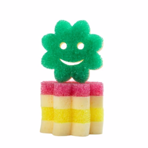 Image Description: A stack of flower-shaped Scrub Mommy sponges against a solid white background, featuring a green flower sponge standing upright on top of a vertical stack of alternating pink and yellow flower sponges.