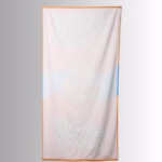 Image Description: A promotional product image showing the reverse side of the vibrant orange Scrub Daddy beach towel set against a neutral gradient background, featuring a lighter, muted reverse print of the central surfing character graphic and surrounding brand lettering.
