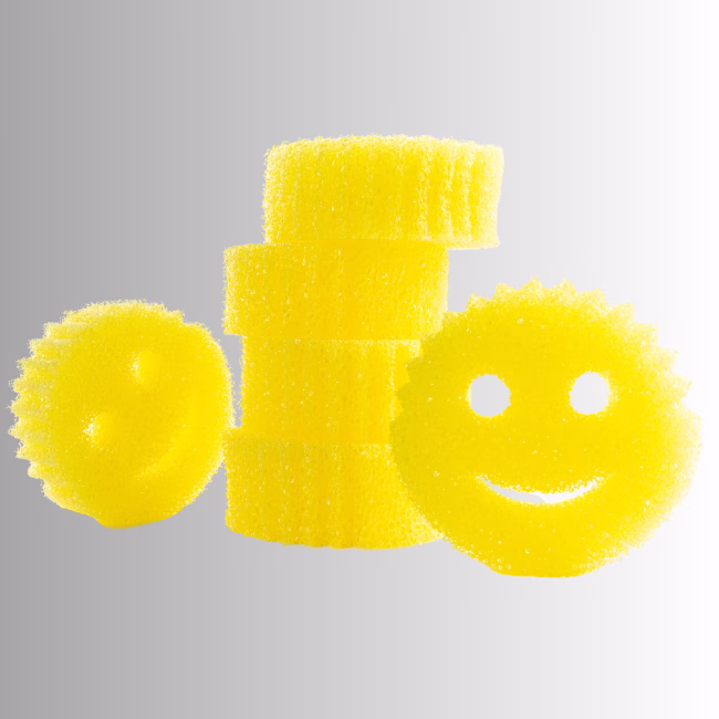 Image Description: A promotional product hero image of a vertical stack of four yellow original Scrub Daddy sponges next to two individual smiley-face sponges set against a neutral gradient background.