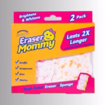Image Description: Packaging for a Scrub Daddy Eraser Mommy 2-pack, featuring an orange and bright pink cardboard box with blue text that reads "Brightens & Whitens," "2 Pack," "Lasts 2X Longer," and "Dual-Sided Eraser + Sponge." The front of the box also lists cleaning features with checkmarks for "Scuffs," "Soapscum," "Dirt," and "Stains," and shows a cutout window displaying the textured dual-sided eraser pads inside.