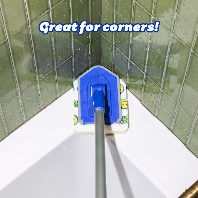 Image Description: A product infographic set against green tiled corner walls and a white tub, featuring bold blue text at the top that reads "Great for corners!" pointing directly to the angled head of the Tub 'n Tile scrubbing tool fitting neatly into the corner grout lines.