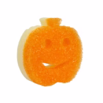 Image Description: An orange pumpkin-shaped Scrub Mommy sponge displayed against a solid white background, featuring a textured orange scrubbing side with a carved face and a visible light yellow foam backing.