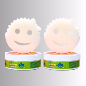 Image Description: A promotional product hero image set against a neutral gradient background, showcasing a 2-pack bundle of Scrub Daddy Power Paste featuring two round tubs of all-purpose cleaning paste topped with matching face-shaped white scrubbing sponges.