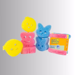 A collection of spring-themed Scrub Daddy products displayed against a neutral background, including a stack of yellow lemon or chick-shaped sponges on the left, a stack of pink flower-shaped sponges in the center, a stack of blue bunny-shaped sponges on the right, and a folded pack of colorful Scrub Daddy microfiber cloths next to them.