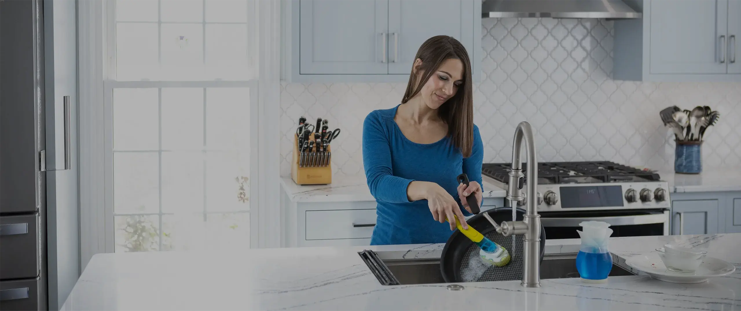 Woman smiling and using a Dish Daddy in a kitchen