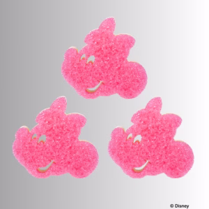 Three pink, textured Minnie Mouse-shaped Scrub Mommy sponges arranged outside of their packaging against a neutral background, with one sponge positioned at the top and two side-by-side below. © Disney