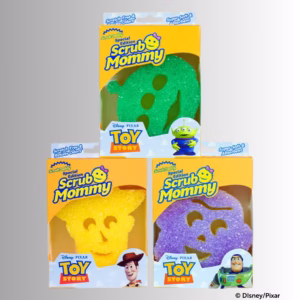 Three individual product boxes for a Toy Story Scrub Mommy special edition set, arranged with a green Alien sponge box on top, a yellow Woody sponge box on the bottom left, and a purple-and-blue Buzz Lightyear sponge box on the bottom right. © Disney/Pixar