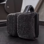 Image Description: Scrub Daddy BBQ Daddy Bristle-Free Griddle Scrubber shown in a close-up shot resting directly on a seasoned black griddle surface, highlighting the textured ArmorTec mesh pads.