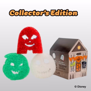 The Scrub Daddy Nightmare Before Christmas Collector's Edition 3-pack against a light grey background. Large orange text at the top reads "Collector's Edition". Below it are three character sponges: a green Oogie Boogie, a white Jack Skellington, and a red Sally sponge. To their right is the collector's packaging, designed to look like the Halloween Town Hall building. The text "© Disney" appears in the bottom right corner.