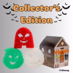 A Collector's Edition Disney Halloween-themed Scrub Daddy 3-pack product display. At the top, the text "Collector's Edition" is shown in orange with a black outline, framed by black flying bat silhouettes. In the foreground, three ghost-shaped sponges are arranged: a red one standing upright, a green one on the bottom left, and a white one on the bottom right, each featuring carved jack-o'-lantern style faces. Next to the sponges is a cardboard packaging box designed to look like a spooky haunted house decorated with orange bunting, a jack-o'-lantern wreath, and ghost graphics. A "© Disney" copyright label appears in the bottom right corner.