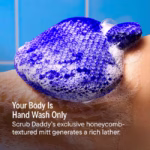 : Image Description: A product feature infographic set against a blue tiled background, showing the soapy blue exfoliating mitt on skin, highlighting "Your Body Is Hand Wash Only" and the exclusive honeycomb-textured lather.