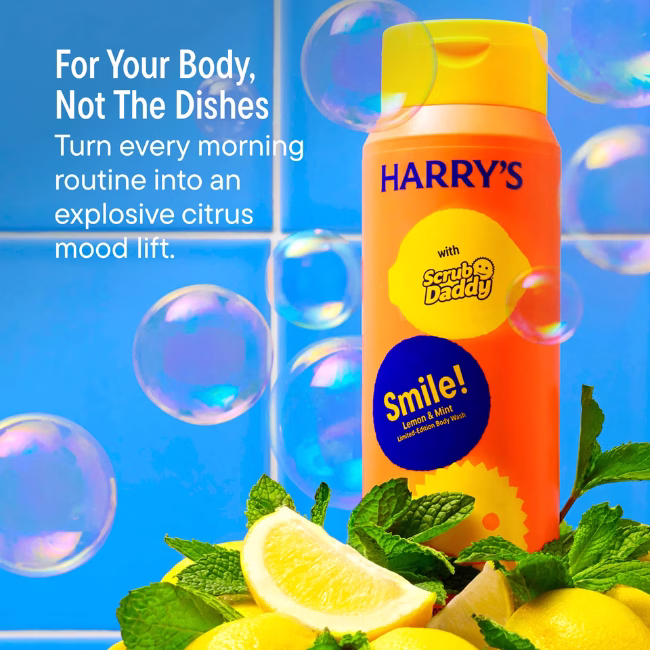 Image Description: A product feature infographic set against a blue tiled background with soap bubbles, featuring the orange body wash bottle surrounded by fresh lemons and mint, highlighting "For Your Body, Not The Dishes" and an explosive citrus mood lift.