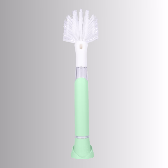 Image Description: A promotional product hero image of the Scrub Baby bristle brush set against a neutral gradient background, featuring a light green and white soap-dispensing wand with a white bristle head.